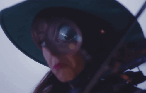 A Woman Wearing A Green Hat And Holding A Violin GIF