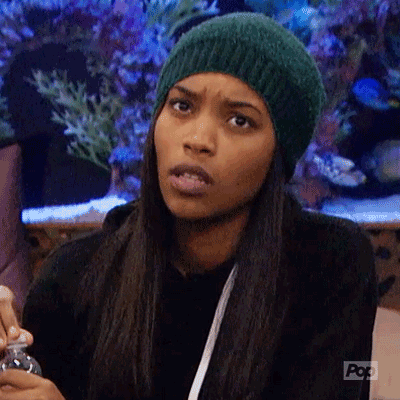 A Woman Wearing A Green Hat Is Making A Funny Face While Holding A Bottle . GIF