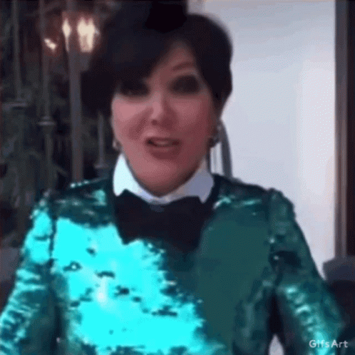 A Woman Wearing A Green Sequined Top And A Black Bow Tie Is Making A Funny Face . GIF