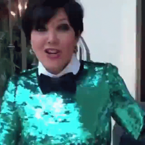 A Woman Wearing A Green Sequined Top And A Bow Tie GIF