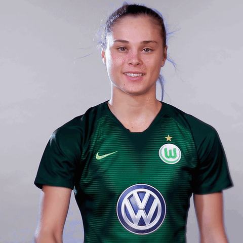 A Woman Wearing A Green Shirt With A Vw Logo GIF