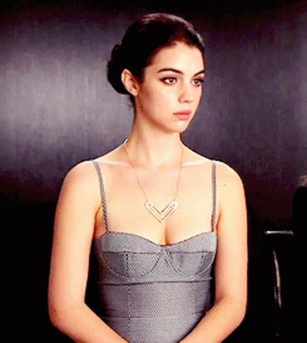 A Woman Wearing A Grey Dress And A Necklace GIF