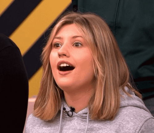 A Woman Wearing A Grey Hoodie Looks Surprised GIF