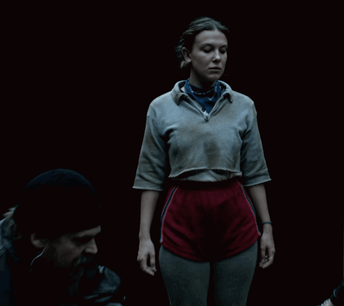 A Woman Wearing A Grey Shirt And A Blue Bandana GIF
