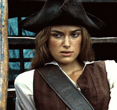 A Woman Wearing A Hat And A Brown Vest GIF