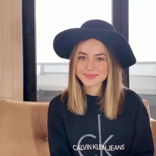 A Woman Wearing A Hat And A Calvin Klein Jeans Shirt GIF