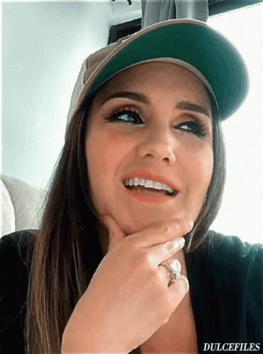 A Woman Wearing A Hat And A Ring Has The Word Dulcefiles On The Bottom Right GIF