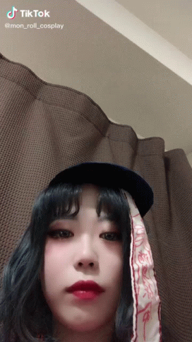 a woman wearing a hat and a scarf with tiktok written on the bottom