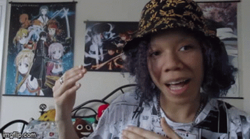 Woman With Hat And Anime Wall Behind GIF