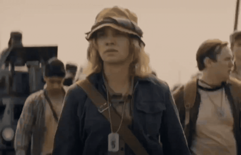 A Woman Wearing A Hat Has A Tag Around Her Neck That Says ' A ' On It GIF