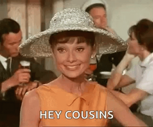 A Woman Wearing A Hat Is Smiling And Saying `` Hey Cousins '' While Standing In Front Of A Group Of People . GIF