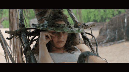 a woman wearing a hat made of leaves and vines