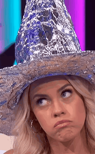 A Woman Wearing A Hat Made Out Of Tin Foil GIF