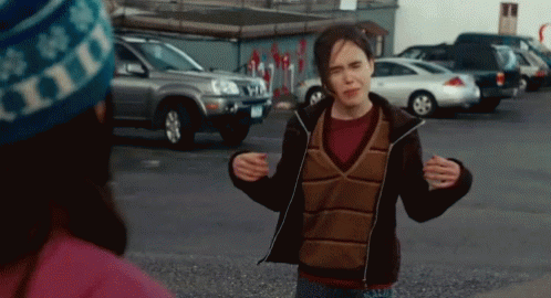 A Woman Wearing A Hat That Says Hills Is Standing In A Parking Lot GIF