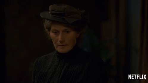 a woman wearing a hat with a netflix logo on the bottom