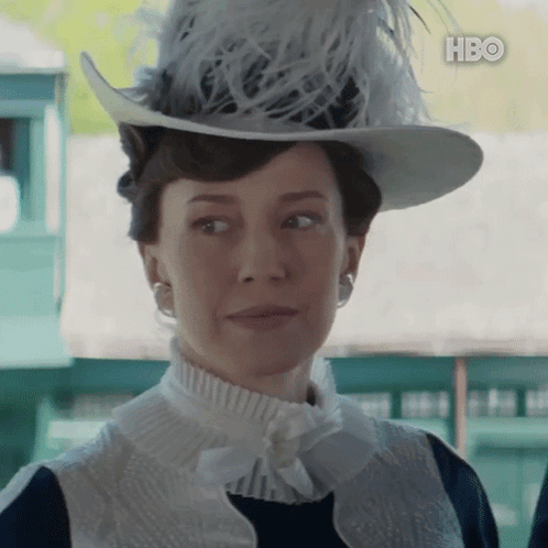 A Woman Wearing A Hat With Feathers And A Hbo Logo GIF