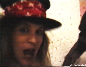 A Woman Wearing A Hat With The Word Alittle Divided On The Bottom Left GIF