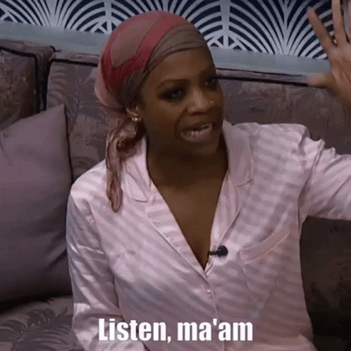 A Woman Wearing A Head Scarf Is Sitting On A Couch And Talking To Someone . GIF