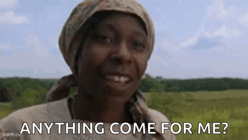 a woman wearing a head scarf is smiling in a field and asking anything come for me .