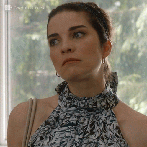 Woman In Floral Top Looking Out Window GIF