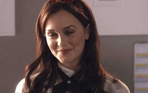A Woman Wearing A Headband And A White Shirt Smiles GIF