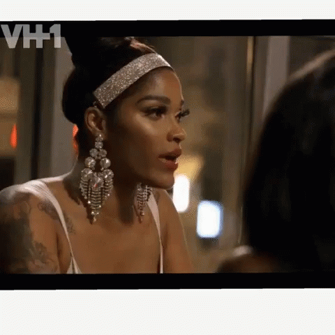 A Woman Wearing A Headband And Earrings Is Talking To Another Woman On A Tv Screen With Vh1 Written On The Bottom GIF