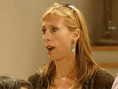 A Woman Wearing A Headband And Earrings Looks Surprised And Shocked GIF