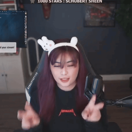 A Woman Wearing A Headband With Bunny Ears Is Giving A Peace Sign In Front Of A Screen That Says 1000 Stars GIF