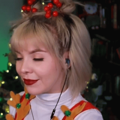 A Woman Wearing A Headband With Red Berries On It Is Smiling . GIF
