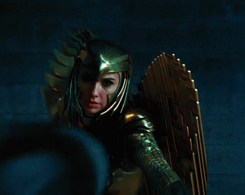 A Woman Wearing A Helmet And Gold Armor Is Holding A Sword GIF