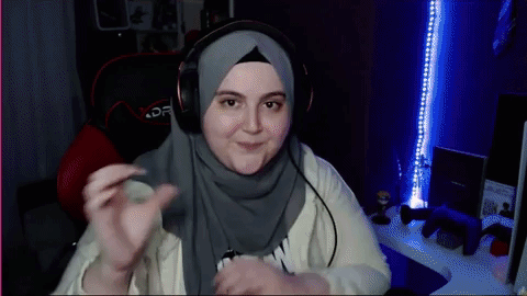 A Woman Wearing A Hijab And Headphones Is Sitting In A Chair GIF