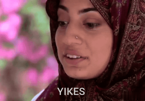 a woman wearing a hijab says " yikes " in front of her face