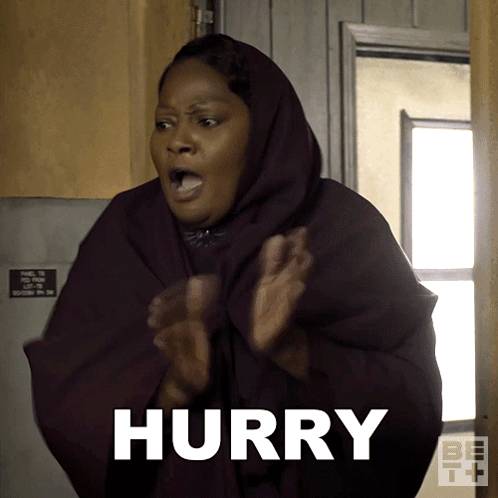 A Woman Wearing A Hooded Cape Says Hurry With Her Hands In The Air GIF