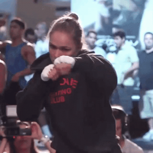 A Woman Wearing A Hoodie That Says Boxing Club On It GIF