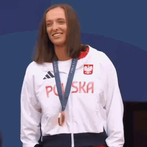 A Woman Wearing A Jacket That Says Polska Is Smiling GIF