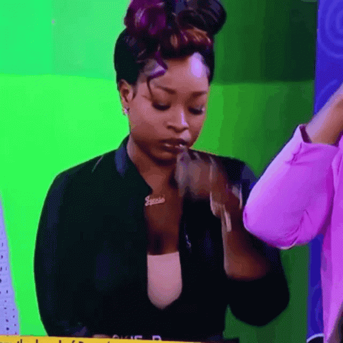 A Woman Wearing A Jacket With A Name Tag That Says Janelle GIF
