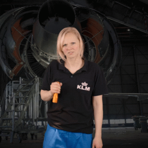 A Woman Wearing A Klm Shirt Is Holding A Flashlight GIF