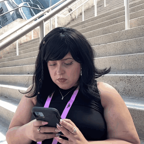 A Woman Wearing A Lanyard That Has The Letter T On It GIF