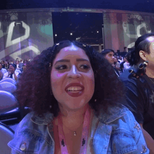 A Woman Wearing A Lanyard That Says ' I Love You ' On It Smiles GIF
