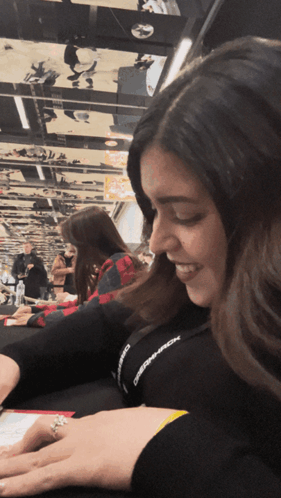 A Woman Wearing A Lanyard That Says ' Observer ' On It Smiles GIF