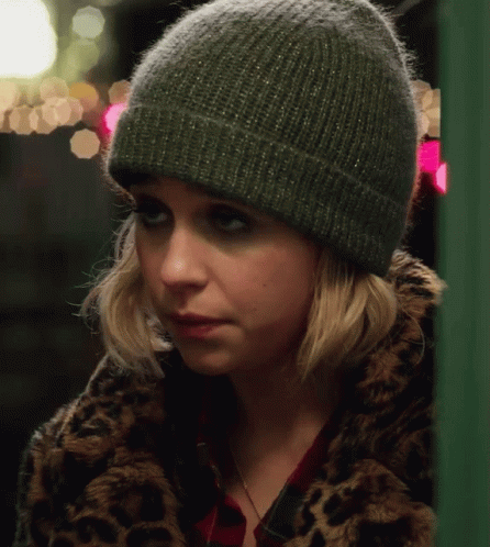 A Woman Wearing A Leopard Print Coat And A Green Beanie GIF