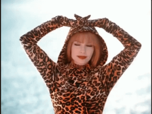 A Woman Wearing A Leopard Print Hooded Top With Her Hands On Her Head GIF