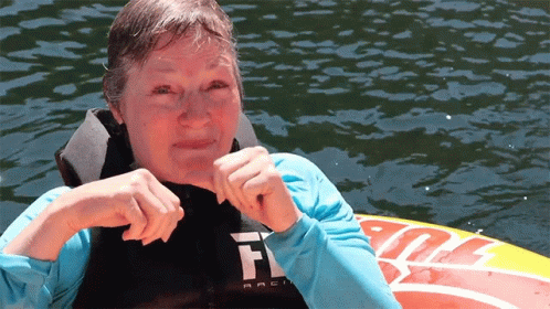 A Woman Wearing A Life Jacket With The Letter F On The Front GIF