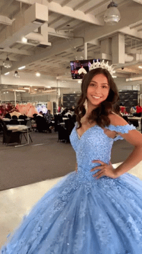 A Woman Wearing A Light Blue Ball Gown With A Tiara On Her Head GIF
