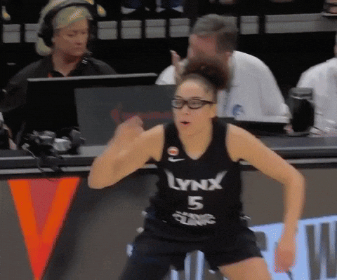 A Woman Wearing A Lynx 5 Jersey Stands On A Bench GIF