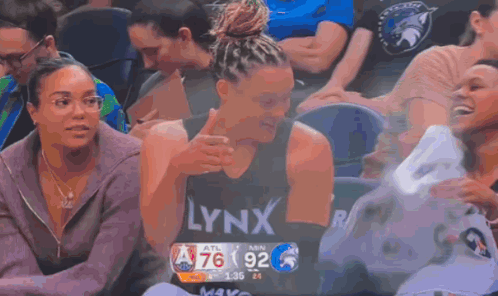 A Woman Wearing A Lynx Shirt Is Sitting In The Stands During A Basketball Game GIF