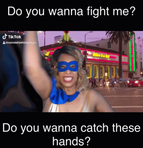 A Woman Wearing A Mask And A Superhero Costume Says Do You Wanna Fight Me Do You Wanna Catch These Hands GIF