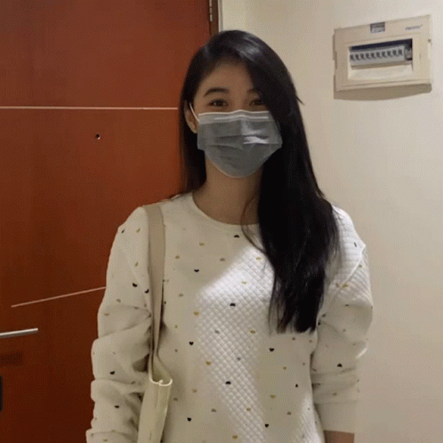 A Woman Wearing A Mask And A White Sweater GIF