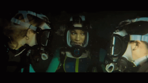 A Woman Wearing A Mask With The Letter D On It Looks At Another Woman GIF