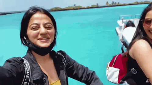 A Woman Wearing A Michael Kors Jacket Smiles While Taking A Selfie GIF